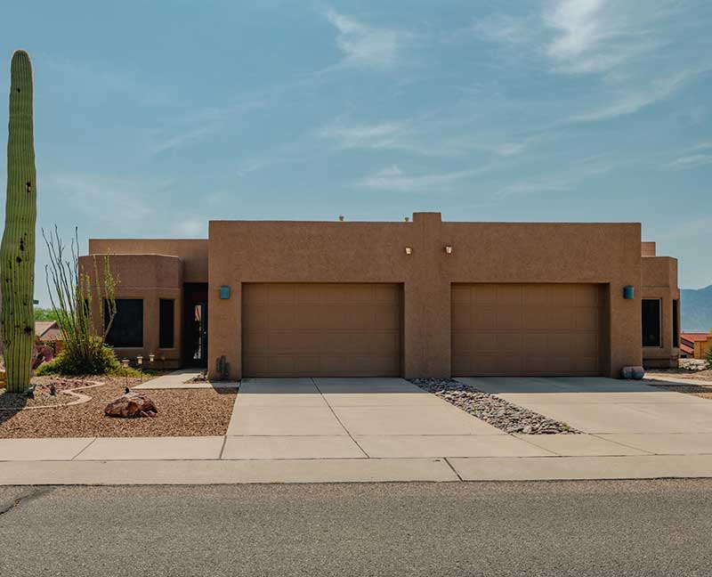 Southwestern-style Tucson home with a three-car garage and desert landscaping featured on the Old Pueblo Home Inspection's Full Home Inspection service page.